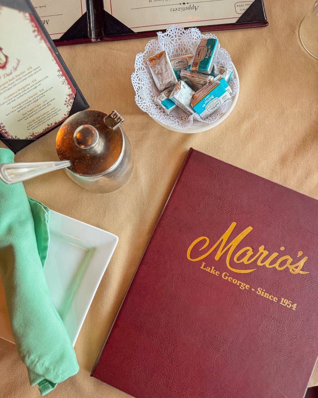 Mario's burgundy leather menu with gold script reading 'Mario's — Lake George — Since 1954'