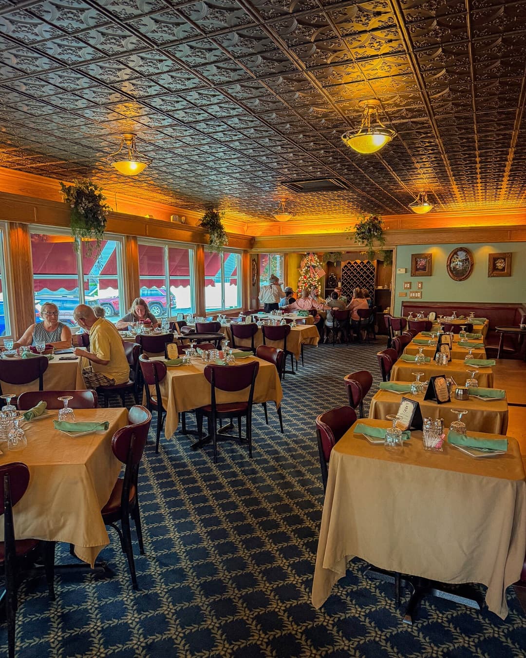 Mario's dining room with its ornate tin ceiling, warm lighting and set tables