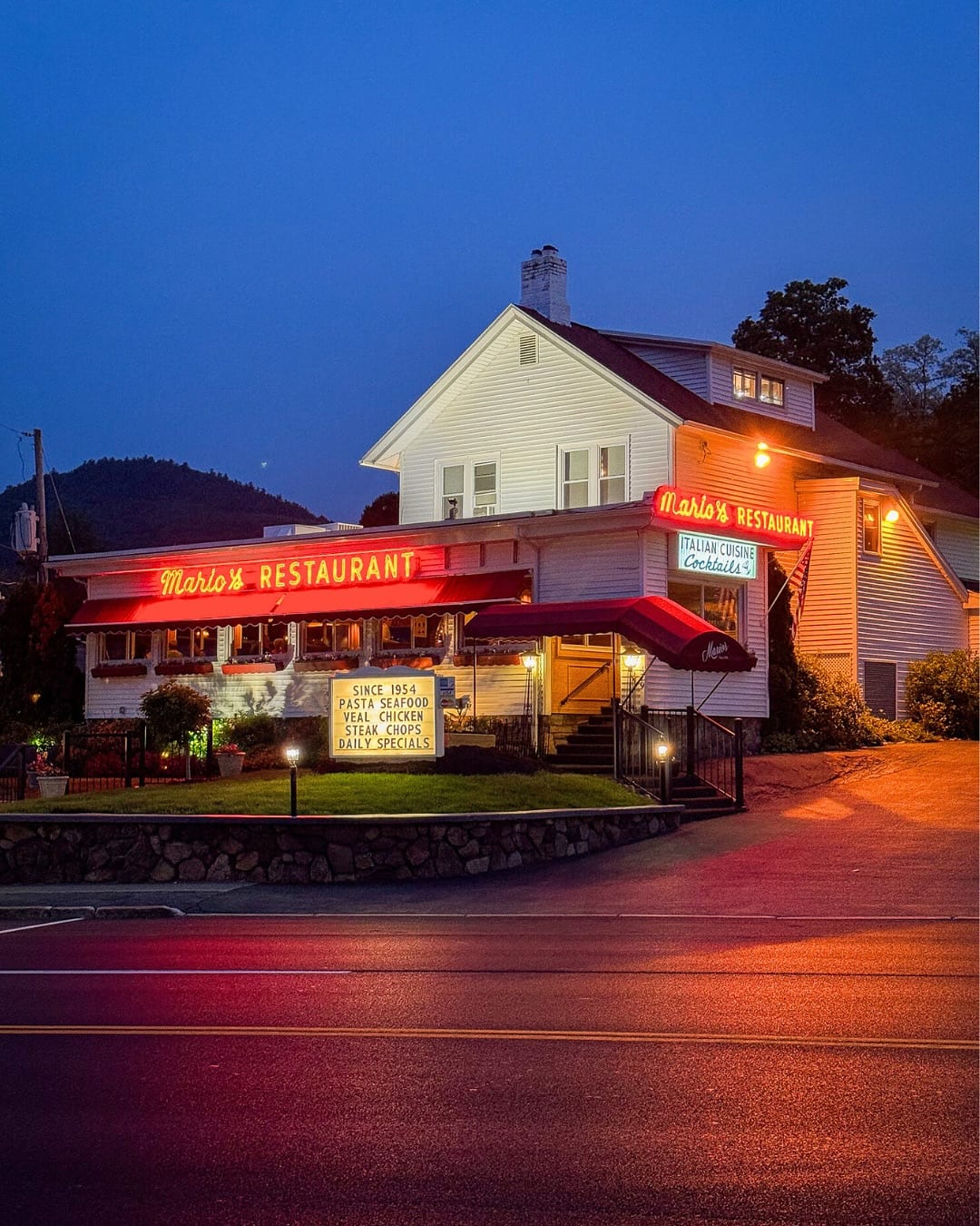 Mario's Restaurant at twilight, its red neon sign glowing over the striped awnings on Canada Street in Lake George